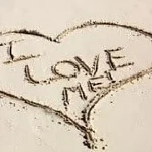 Hart in het zand met de tekst ‘LOVE ME’.